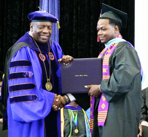 Shown above is Edward Waters College President Nathaniel Glover on the job presenting a degree to Bernard Argurs.